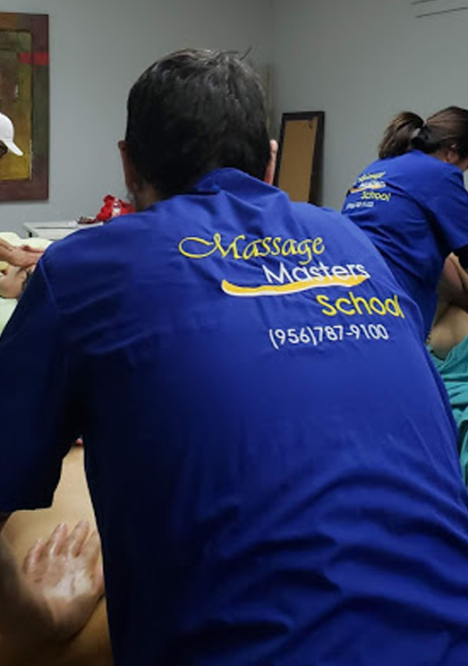 Massage Masters School student wearing scrubs with the school logo on the back